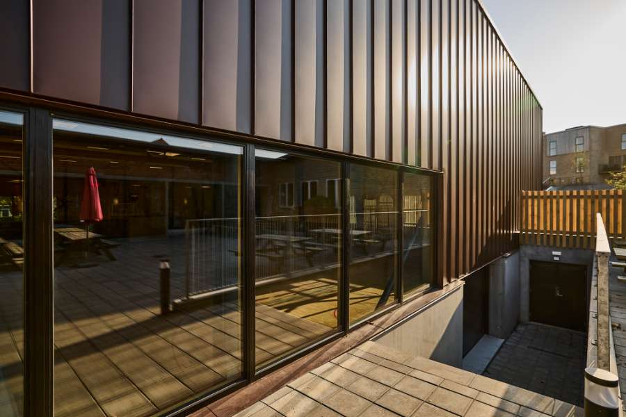 New sports hall in the “forest” wrapped in acorn-brown steel profiles, Risskov Efterskole, Tretommervej 31A, 8240 Risskov, Denmark